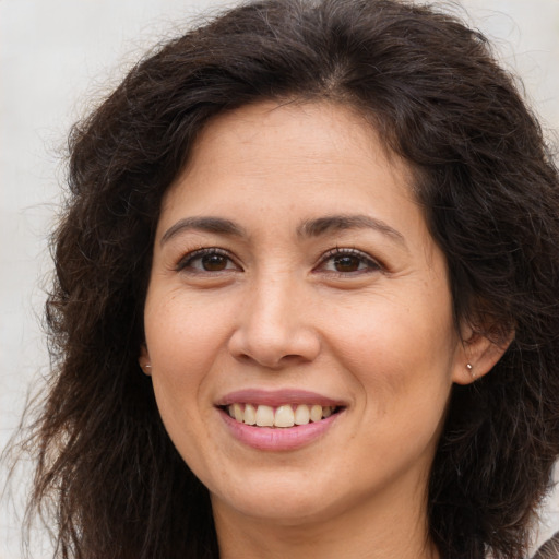 Joyful white adult female with long  brown hair and brown eyes