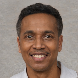 Joyful black adult male with short  black hair and brown eyes