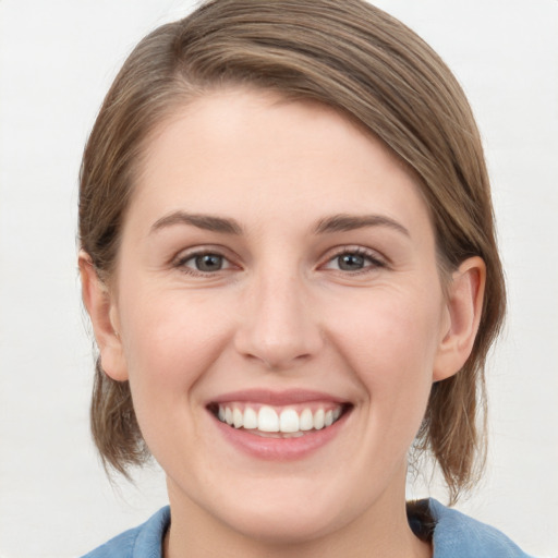 Joyful white young-adult female with medium  brown hair and blue eyes