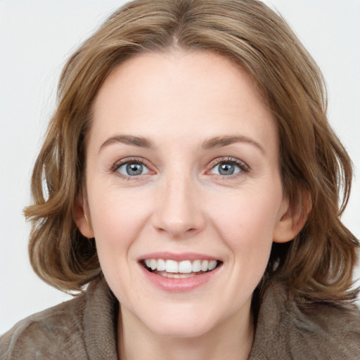 Joyful white young-adult female with medium  brown hair and blue eyes