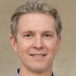 Joyful white adult male with short  brown hair and grey eyes