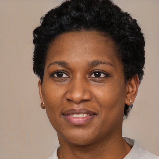 Joyful black adult female with short  black hair and brown eyes