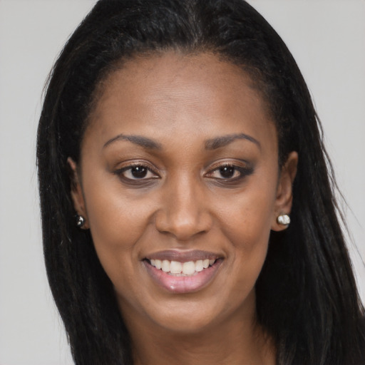 Joyful black young-adult female with long  brown hair and brown eyes