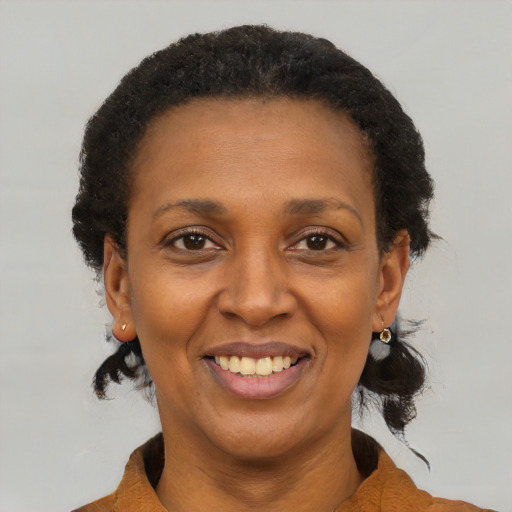 Joyful black adult female with short  brown hair and brown eyes