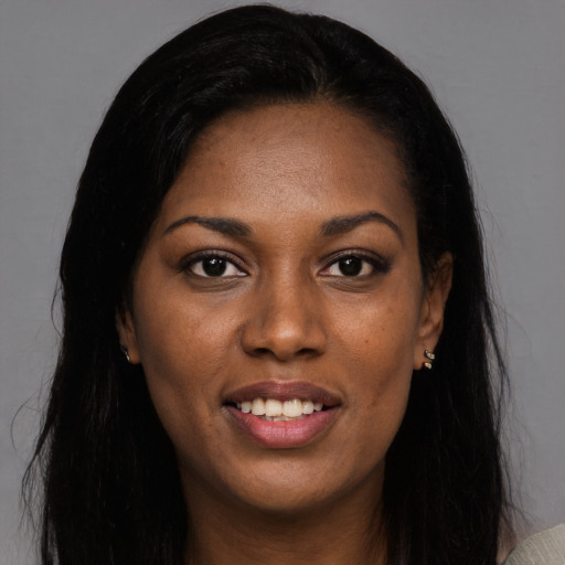 Joyful black young-adult female with long  black hair and brown eyes