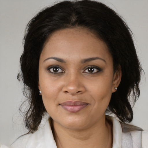 Joyful black adult female with medium  brown hair and brown eyes