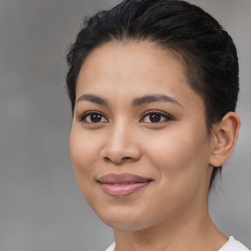 Joyful latino young-adult female with medium  brown hair and brown eyes