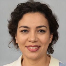 Joyful latino adult female with medium  brown hair and brown eyes