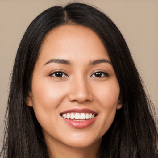 Joyful latino young-adult female with long  brown hair and brown eyes