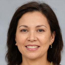 Joyful white adult female with long  brown hair and brown eyes