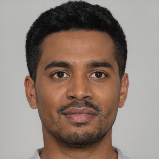 Joyful black young-adult male with short  black hair and brown eyes