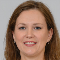 Joyful white adult female with long  brown hair and grey eyes