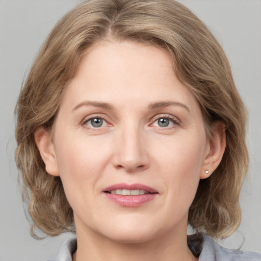 Joyful white adult female with medium  brown hair and grey eyes