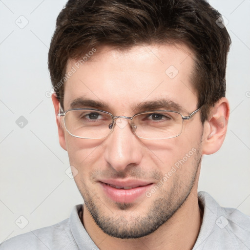 Joyful white young-adult male with short  brown hair and grey eyes