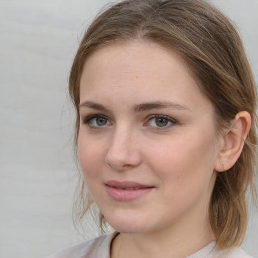 Joyful white young-adult female with medium  brown hair and blue eyes