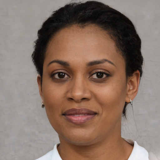 Joyful black adult female with short  black hair and brown eyes
