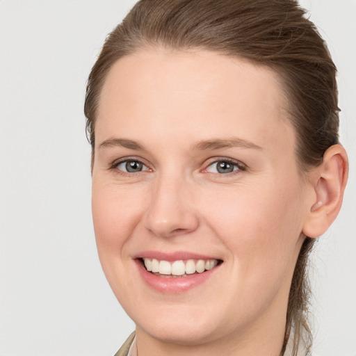 Joyful white young-adult female with medium  brown hair and grey eyes