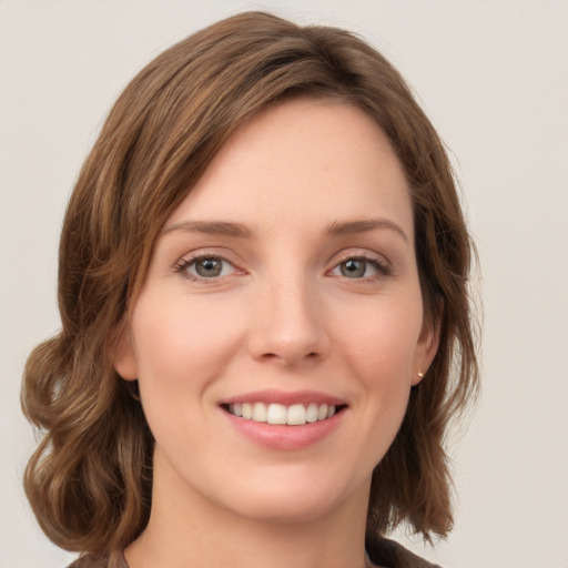 Joyful white young-adult female with medium  brown hair and green eyes