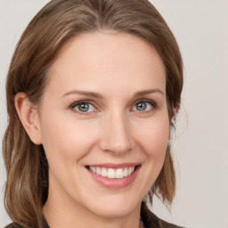 Joyful white young-adult female with medium  brown hair and grey eyes