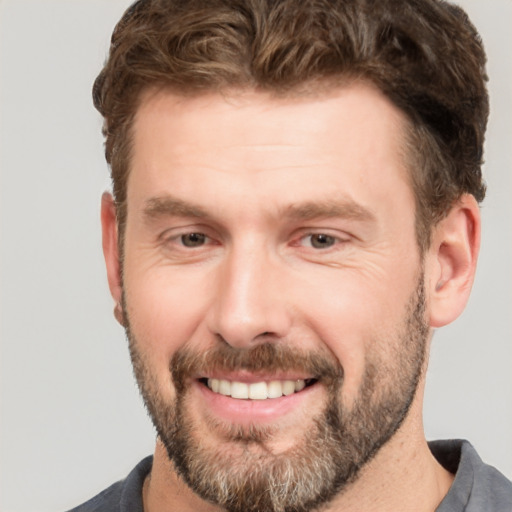 Joyful white adult male with short  brown hair and brown eyes