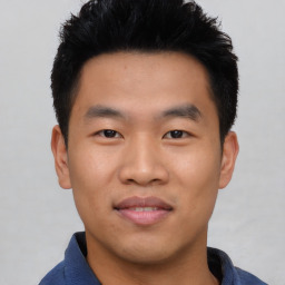 Joyful asian young-adult male with short  black hair and brown eyes