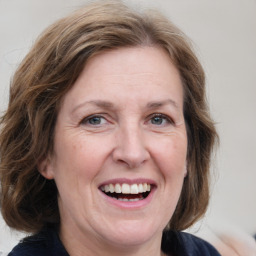 Joyful white adult female with medium  brown hair and grey eyes