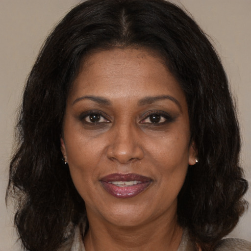 Joyful black adult female with medium  brown hair and brown eyes