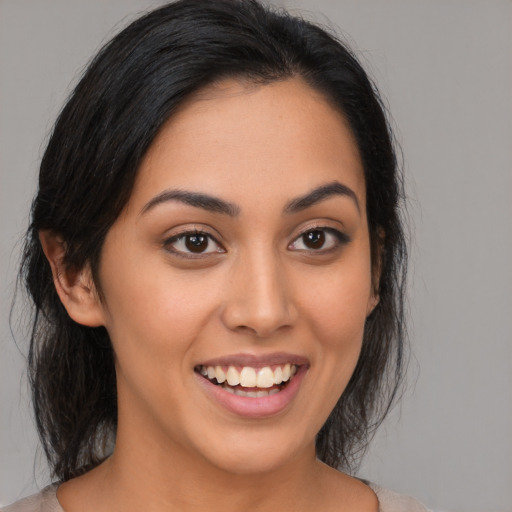 Joyful latino young-adult female with medium  black hair and brown eyes