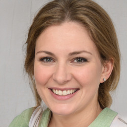 Joyful white young-adult female with medium  brown hair and green eyes