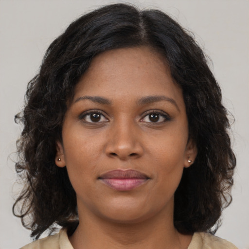 Joyful black young-adult female with long  brown hair and brown eyes