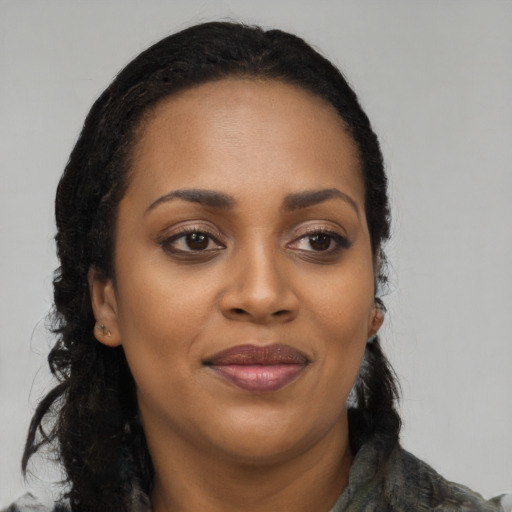 Joyful black young-adult female with long  brown hair and brown eyes