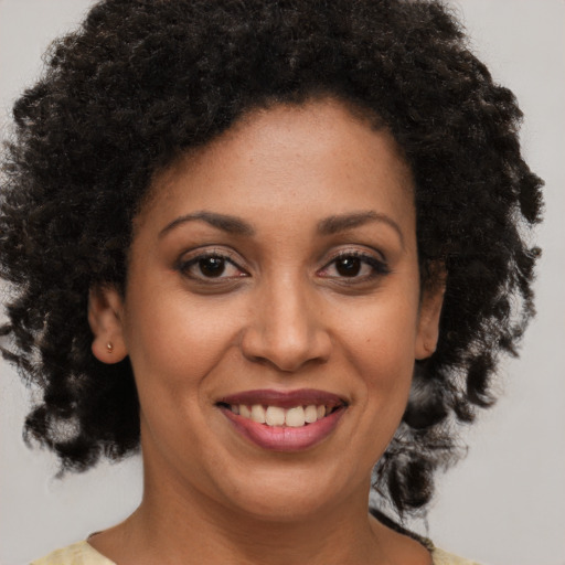 Joyful black young-adult female with medium  brown hair and brown eyes