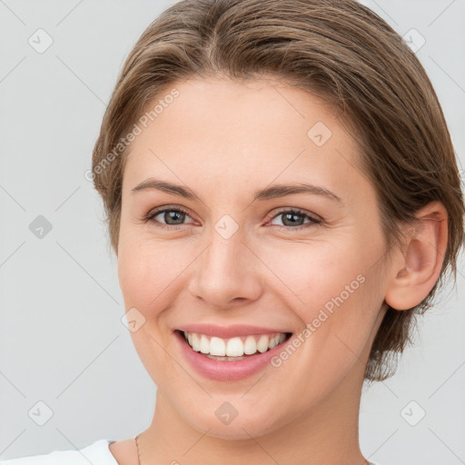 Joyful white young-adult female with medium  brown hair and grey eyes