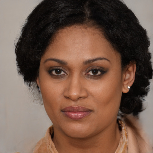 Joyful black young-adult female with long  brown hair and brown eyes