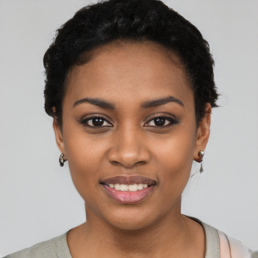 Joyful black young-adult female with short  black hair and brown eyes