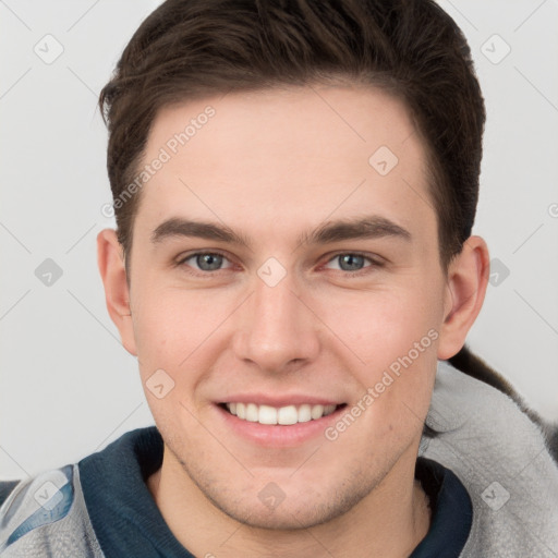 Joyful white young-adult male with short  brown hair and grey eyes