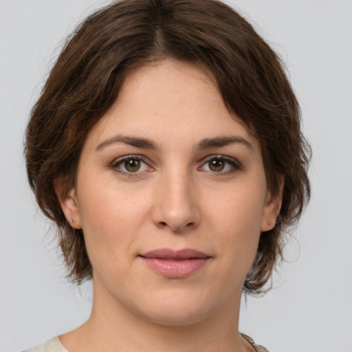 Joyful white young-adult female with medium  brown hair and green eyes