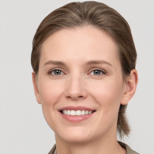 Joyful white young-adult female with short  brown hair and grey eyes