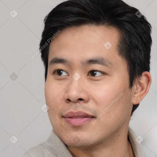 Joyful asian young-adult male with short  black hair and brown eyes