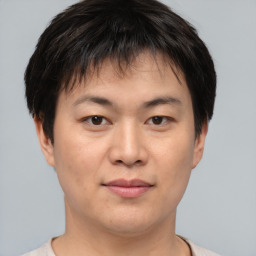 Joyful asian young-adult male with short  brown hair and brown eyes