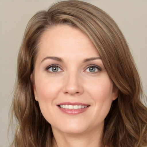 Joyful white young-adult female with long  brown hair and grey eyes