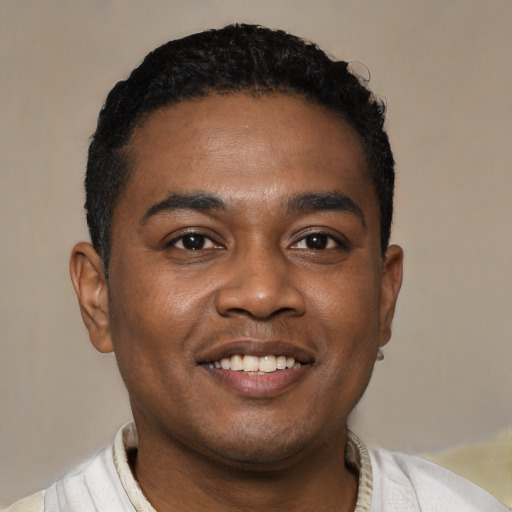 Joyful black young-adult male with short  black hair and brown eyes