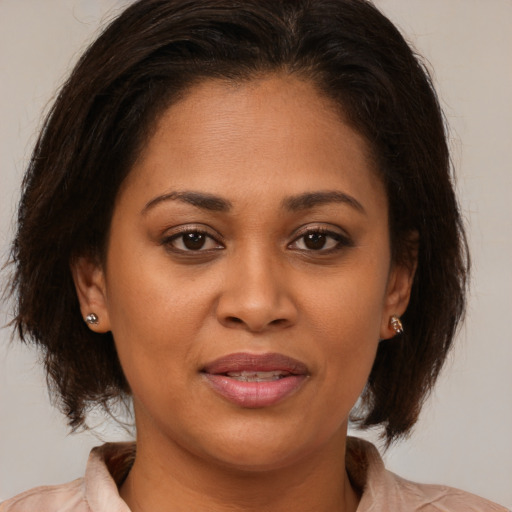 Joyful black young-adult female with medium  brown hair and brown eyes