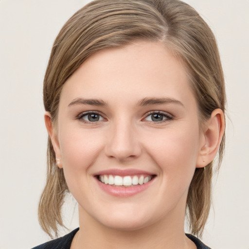 Joyful white young-adult female with medium  brown hair and grey eyes