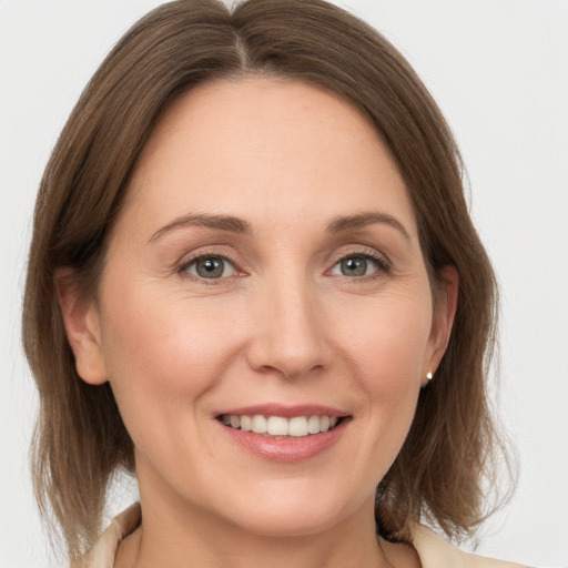 Joyful white young-adult female with medium  brown hair and grey eyes