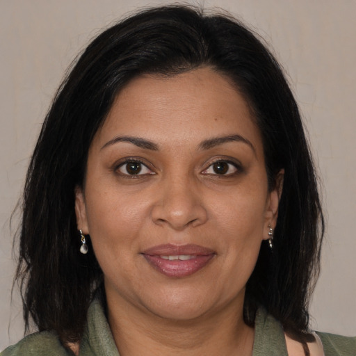 Joyful black adult female with long  brown hair and brown eyes