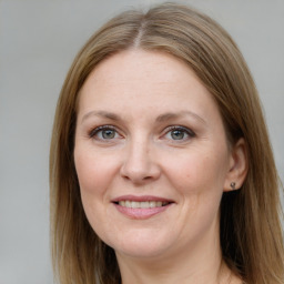 Joyful white adult female with long  brown hair and grey eyes