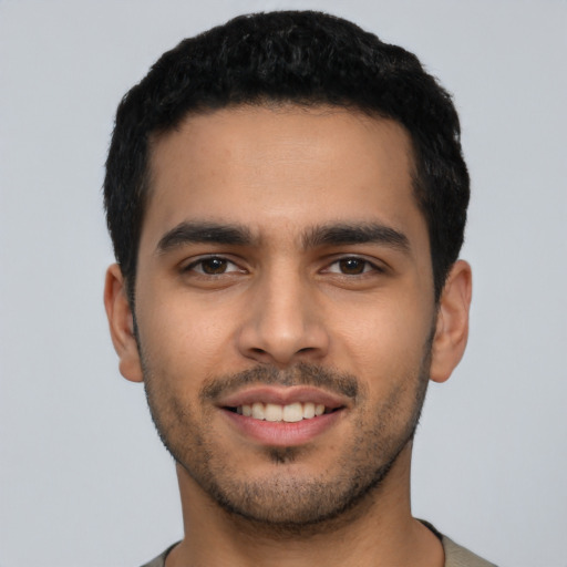 Joyful latino young-adult male with short  black hair and brown eyes