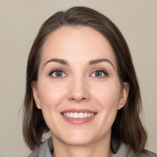 Joyful white young-adult female with medium  brown hair and grey eyes