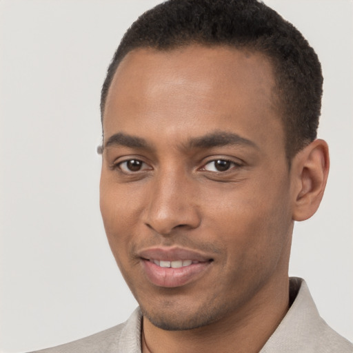 Joyful black young-adult male with short  brown hair and brown eyes